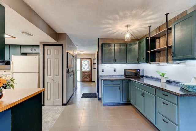 35 Whippoorwill Ln, Ormond Beach, FL 32174 - kitchen featuring freestanding refrigerator, open shelves, dark countertops, and light tile patterned floors