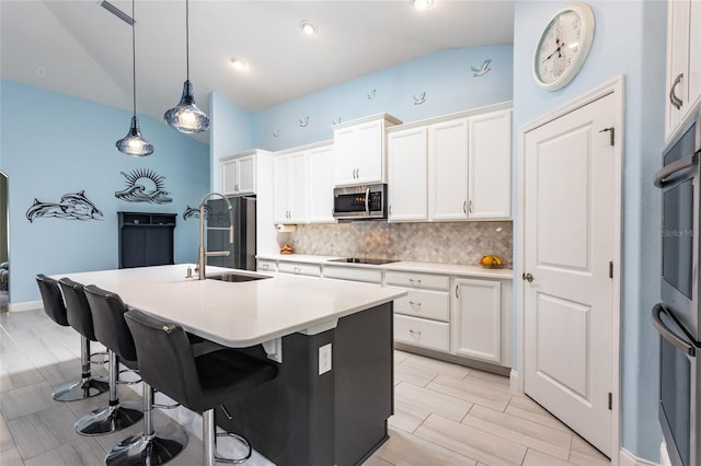 11 Tideway Trl, Palm Coast, FL 32137 - kitchen featuring stainless steel microwave, a sink, tasteful backsplash, a kitchen island with sink, and lofted ceiling