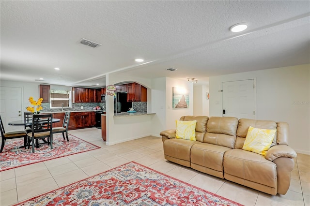 443 Polk Ave, Orange Park, FL 32065 - living area with arched walkways, recessed lighting, light tile patterned floors, a textured ceiling, and baseboards