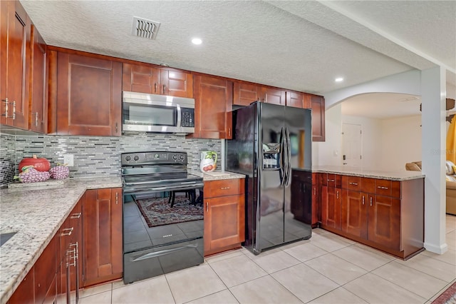443 Polk Ave, Orange Park, FL 32065 - kitchen with black appliances, arched walkways, tasteful backsplash, light stone countertops, and recessed lighting