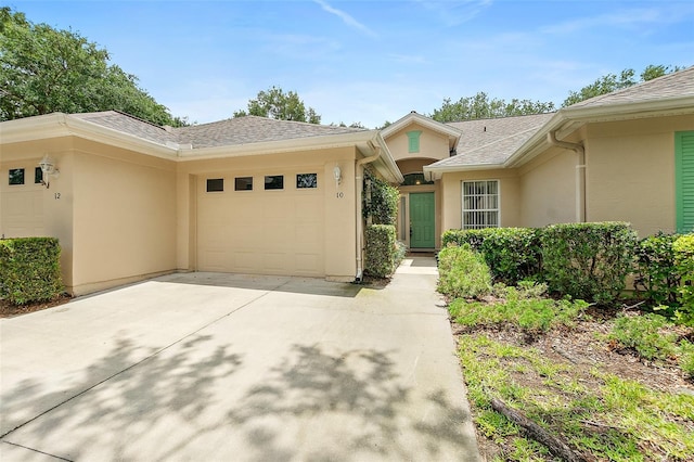 10 Chatham Pl Unit 10, Palm Coast, FL 32164 - view of front of property featuring driveway, an attached garage, stucco siding, and a shingled roof
