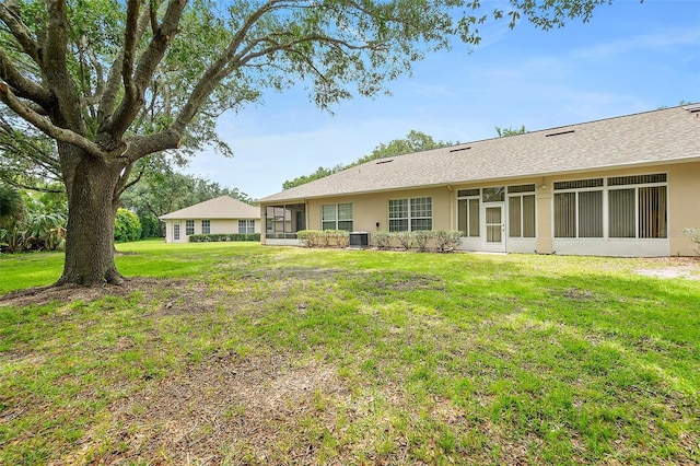 10 Chatham Pl Unit 10, Palm Coast, FL 32164 - back of house featuring central AC, a yard, stucco siding, and a sunroom