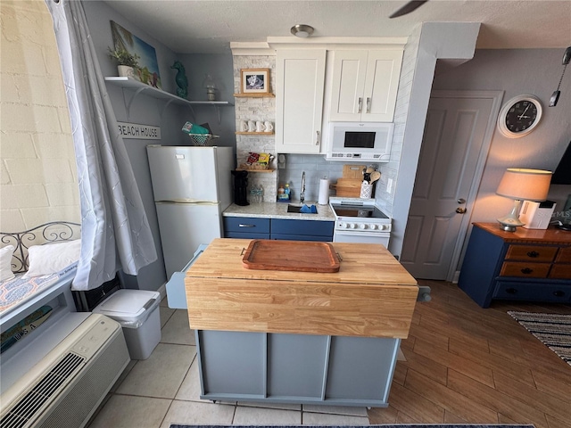 1233 S Atlantic Ave Unit 3070, Daytona Beach, FL 32118 - kitchen with white appliances, open shelves, white cabinets, decorative backsplash, and wooden counters