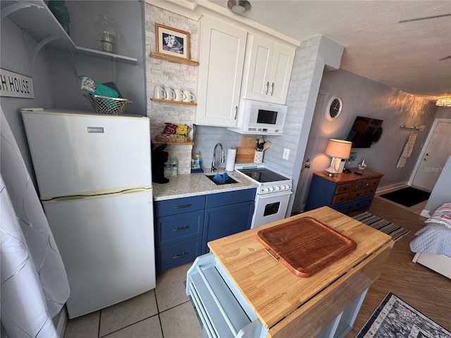 1233 S Atlantic Ave Unit 3070, Daytona Beach, FL 32118 - kitchen featuring a sink, white appliances, open shelves, light countertops, and blue cabinets