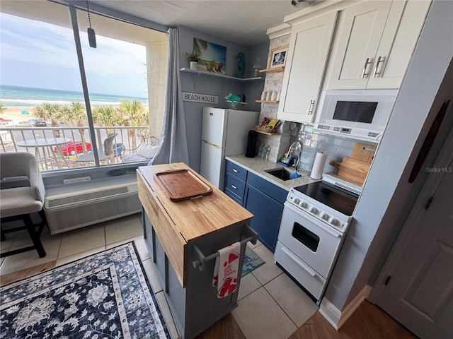 1233 S Atlantic Ave Unit 3070, Daytona Beach, FL 32118 - kitchen with white appliances, tasteful backsplash, white cabinetry, butcher block counters, and open shelves