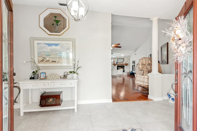 30 Clermont Ct, Palm Coast, FL 32137 - entrance foyer featuring ceiling fan, a fireplace, vaulted ceiling, light tile patterned floors, and baseboards