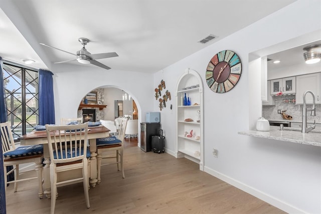 30 Clermont Ct, Palm Coast, FL 32137 - dining area with ceiling fan, arched walkways, wood finished floors, baseboards, and built in shelves