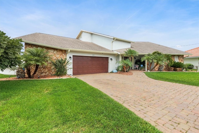 30 Clermont Ct, Palm Coast, FL 32137 - view of front of home featuring a front lawn, a garage, decorative driveway, stucco siding, and stone siding