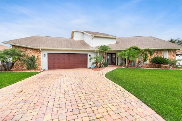 30 Clermont Ct, Palm Coast, FL 32137 - view of front of house with stone siding, decorative driveway, a garage, and a front lawn