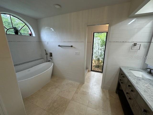 381 E Joplin Ct, Hernando, FL 34442 - bathroom with vanity, a freestanding tub, tile walls, plenty of natural light, and tile patterned flooring