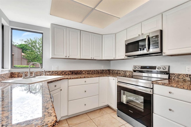 13 Hembury Ln, Palm Coast, FL 32137 - kitchen with stainless steel appliances, a sink, white cabinets, and light tile patterned floors
