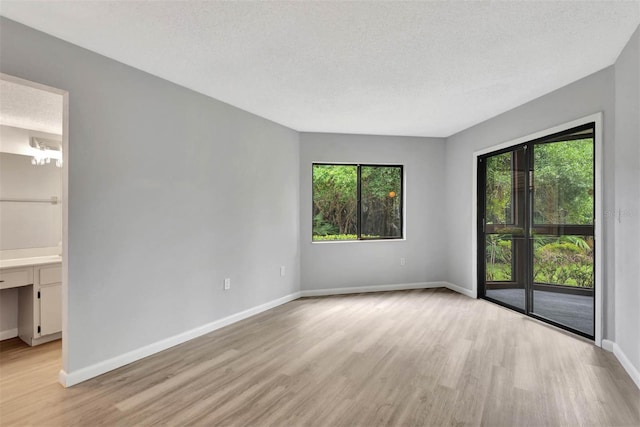 13 Hembury Ln, Palm Coast, FL 32137 - unfurnished room featuring light wood-type flooring, baseboards, and a textured ceiling