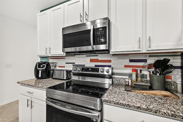 24 Beacon Mill Ln, Palm Coast, FL 32137 - kitchen featuring stainless steel appliances, white cabinets, dark stone counters, and baseboards
