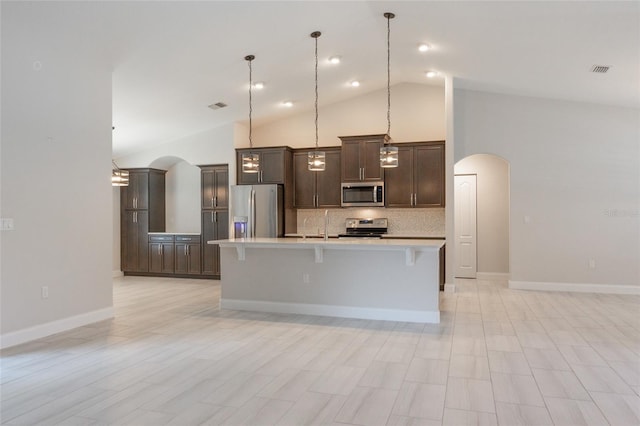 127 Wynnfield Dr, Palm Coast, FL 32164 - kitchen with appliances with stainless steel finishes, arched walkways, light countertops, decorative backsplash, and high vaulted ceiling