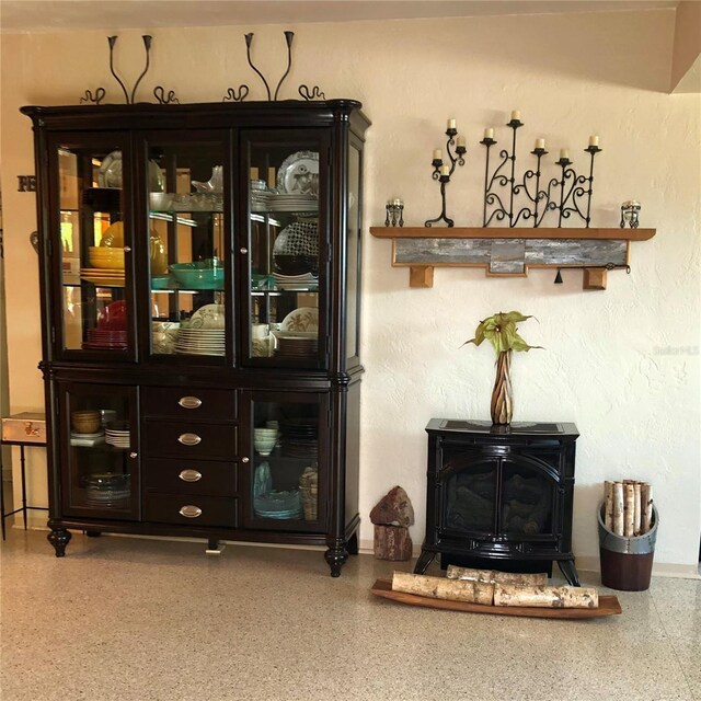 33 Camellia Dr, Ormond Beach, FL 32176 - bar area featuring a wood stove, speckled floor, and baseboards