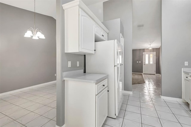 88 Pritchard Dr, Palm Coast, FL 32164 - kitchen with freestanding refrigerator, light countertops, a chandelier, and white cabinetry