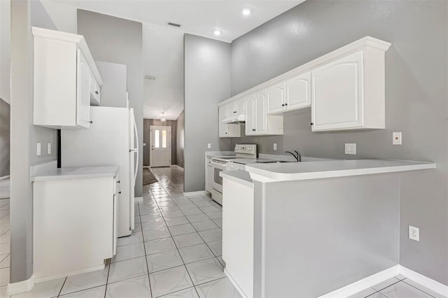88 Pritchard Dr, Palm Coast, FL 32164 - kitchen with white appliances, a peninsula, white cabinetry, light countertops, and under cabinet range hood