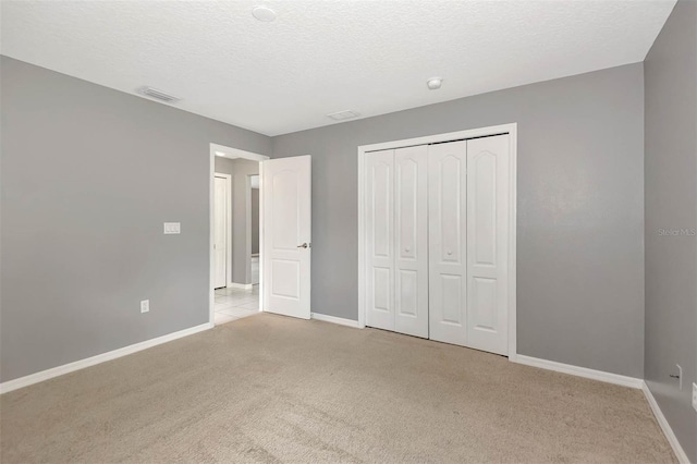 88 Pritchard Dr, Palm Coast, FL 32164 - unfurnished bedroom featuring light carpet, a textured ceiling, and a closet