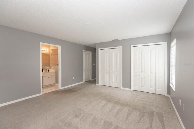 88 Pritchard Dr, Palm Coast, FL 32164 - unfurnished bedroom featuring carpet flooring, two closets, and ensuite bath