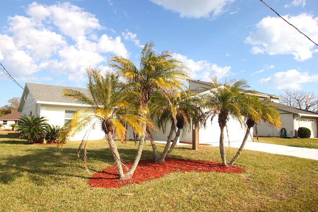 19 Cedarfield Ct, Palm Coast, FL 32137 - obstructed view of property featuring concrete driveway, a front yard, and stucco siding