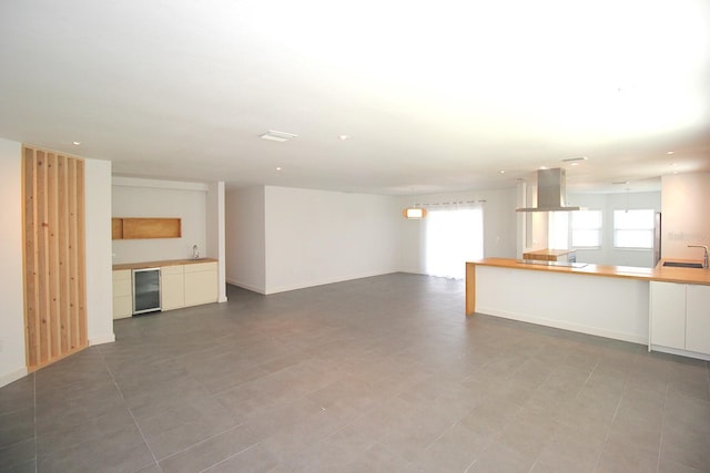 19 Cedarfield Ct, Palm Coast, FL 32137 - unfurnished living room with a sink, wine cooler, recessed lighting, and baseboards