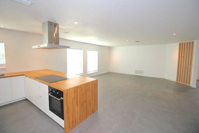 19 Cedarfield Ct, Palm Coast, FL 32137 - kitchen with black appliances, island range hood, white cabinets, recessed lighting, and a peninsula