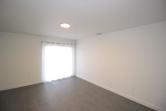 19 Cedarfield Ct, Palm Coast, FL 32137 - empty room featuring baseboards and dark tile patterned floors