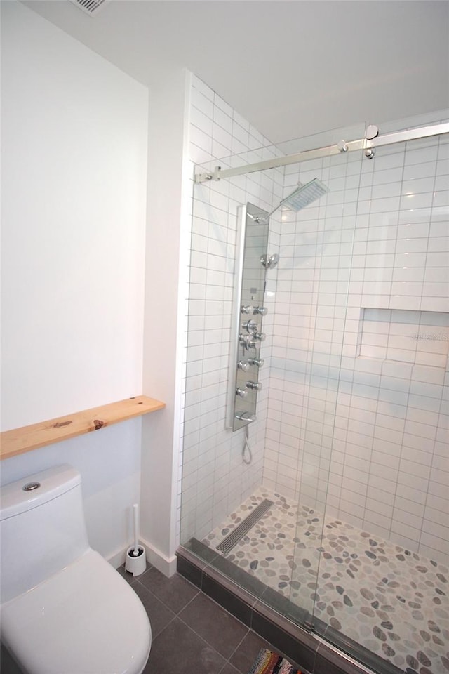 19 Cedarfield Ct, Palm Coast, FL 32137 - bathroom with tile patterned flooring, a stall shower, toilet, and baseboards