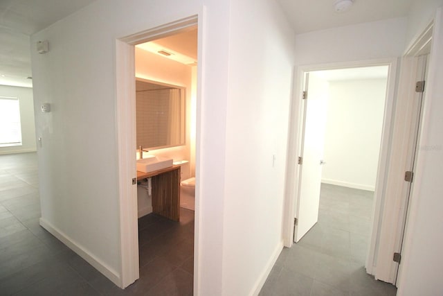 19 Cedarfield Ct, Palm Coast, FL 32137 - corridor featuring baseboards, tile patterned floors, and a sink