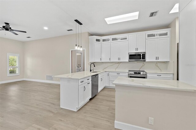 38 Kingsley Cir, Ormond Beach, FL 32174 - kitchen with appliances with stainless steel finishes, a peninsula, a sink, tasteful backsplash, and light wood-style floors