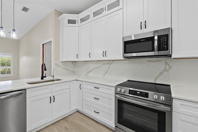 38 Kingsley Cir, Ormond Beach, FL 32174 - kitchen featuring appliances with stainless steel finishes, a sink, light stone countertops, and backsplash