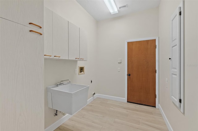 38 Kingsley Cir, Ormond Beach, FL 32174 - washroom with cabinet space, hookup for a washing machine, baseboards, and light wood finished floors