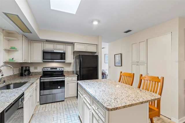 179 Frankford Ln, Palm Coast, FL 32137 - kitchen featuring black appliances, a sink, open shelves, a center island, and light stone counters
