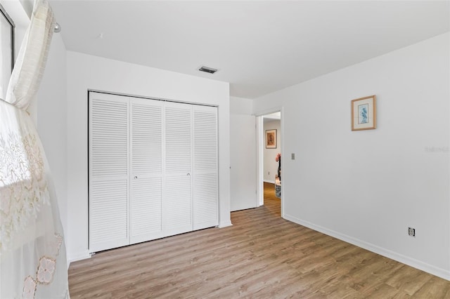 179 Frankford Ln, Palm Coast, FL 32137 - unfurnished bedroom with wood finished floors, a closet, and baseboards