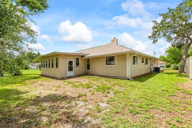 179 Frankford Ln, Palm Coast, FL 32137 - rear view of house with a chimney, central AC, and a shingled roof