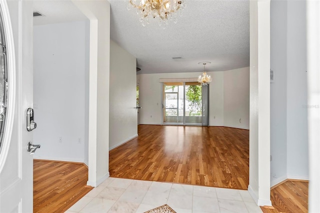 42 Raintree Pl, Palm Coast, FL 32164 - unfurnished room with a chandelier, light wood-style flooring, and a textured ceiling