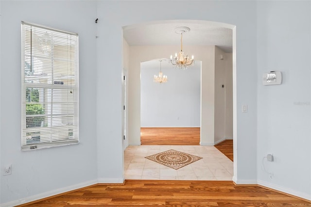42 Raintree Pl, Palm Coast, FL 32164 - entrance foyer featuring arched walkways, a chandelier, wood finished floors, and baseboards