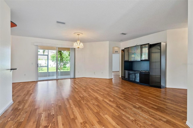 42 Raintree Pl, Palm Coast, FL 32164 - unfurnished living room featuring a chandelier, light wood-style flooring, and a textured ceiling