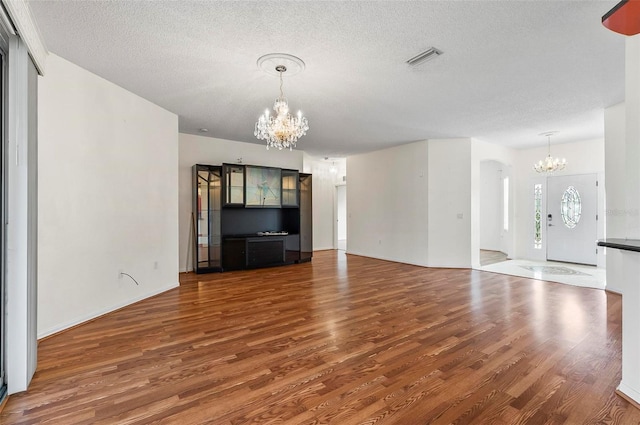 42 Raintree Pl, Palm Coast, FL 32164 - unfurnished living room featuring a chandelier, wood finished floors, and a textured ceiling