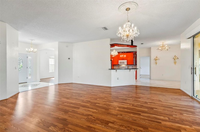 42 Raintree Pl, Palm Coast, FL 32164 - unfurnished living room featuring a chandelier, wood finished floors, and a textured ceiling