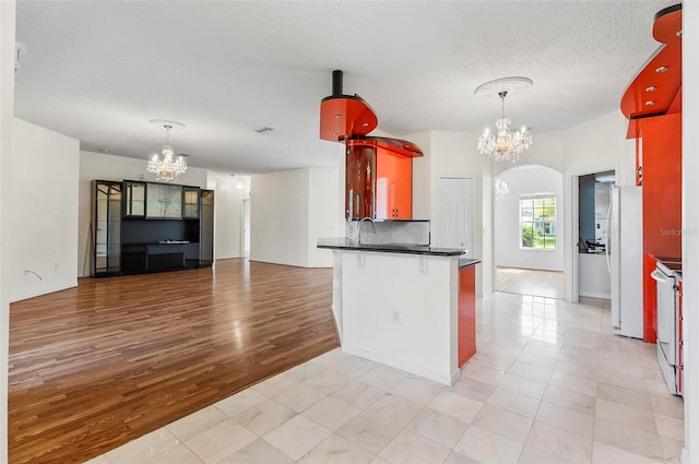 42 Raintree Pl, Palm Coast, FL 32164 - kitchen with a chandelier, dark countertops, white appliances, open floor plan, and a textured ceiling