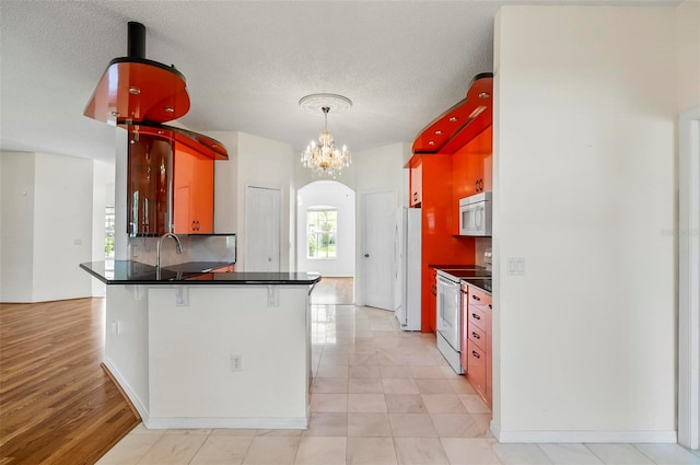 42 Raintree Pl, Palm Coast, FL 32164 - kitchen featuring white appliances, dark countertops, a peninsula, tasteful backsplash, and a sink