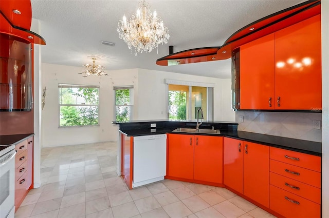 42 Raintree Pl, Palm Coast, FL 32164 - kitchen featuring a sink, white appliances, a chandelier, a peninsula, and dark countertops