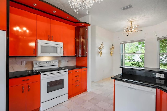 42 Raintree Pl, Palm Coast, FL 32164 - kitchen featuring white appliances, a chandelier, decorative backsplash, dark countertops, and a textured ceiling