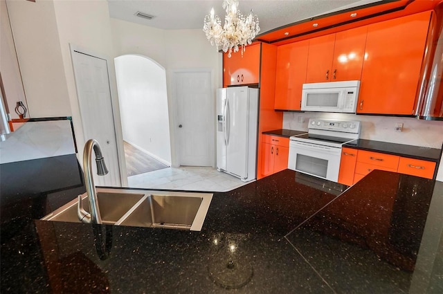 42 Raintree Pl, Palm Coast, FL 32164 - kitchen with white appliances, a sink, arched walkways, a chandelier, and dark countertops