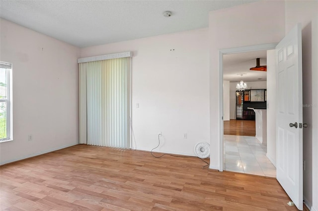 42 Raintree Pl, Palm Coast, FL 32164 - empty room with a chandelier, light wood-style flooring, and baseboards