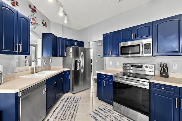 4 Seathorn Path, Palm Coast, FL 32164 - kitchen featuring appliances with stainless steel finishes, blue cabinets, light countertops, a textured ceiling, and light tile patterned flooring