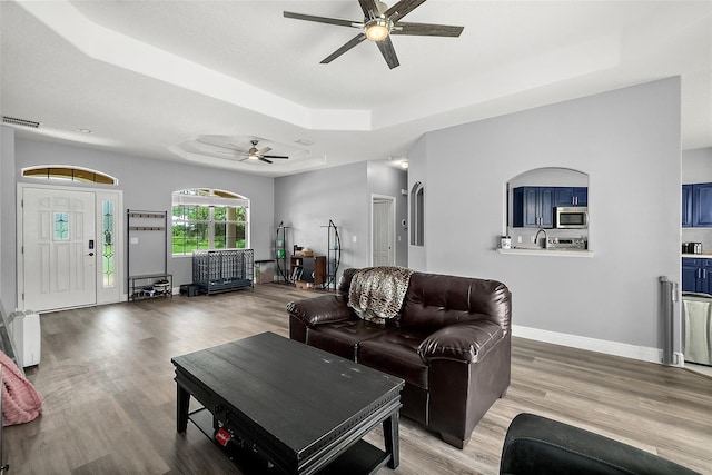 4 Seathorn Path, Palm Coast, FL 32164 - living area featuring ceiling fan, a tray ceiling, and light wood-style flooring