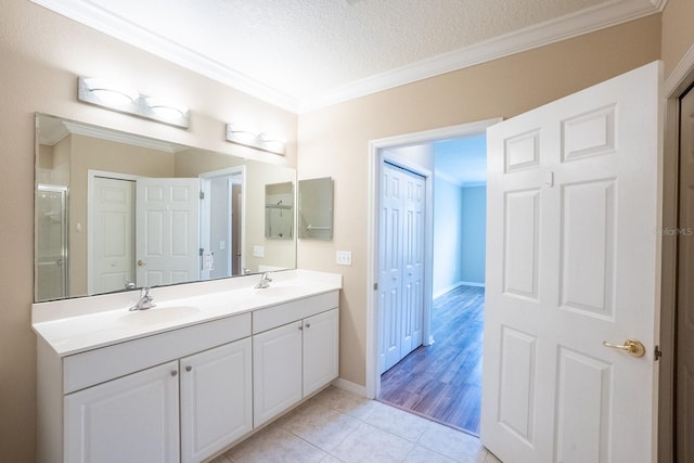 1400 Canopy Walk Ln Unit 1413, Palm Coast, FL 32137 - full bathroom featuring ornamental molding, double vanity, tile patterned flooring, a textured ceiling, and a shower with shower door