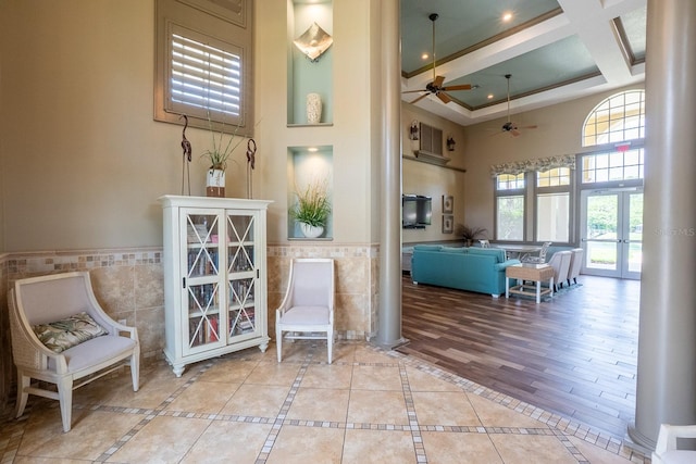1400 Canopy Walk Ln Unit 1413, Palm Coast, FL 32137 - living area featuring a towering ceiling, tile walls, a ceiling fan, a wainscoted wall, and coffered ceiling